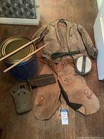 lot overview showing drum, jacket, chaps, canteen, mess kit, belt