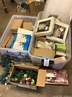 Two plastic totes with boxed and loose string lights, Stats C7 set, novelty bulbs visible