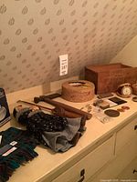 Overview showing scarf, doll, wooden tools, boxes, medals, clock