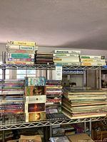 Overall lot showing VHS tapes, DVDs, LPs and Vectrex games on shelving