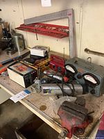 Workbench view showing tester, radios, flashlights, vise, squares and other tools