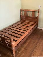 Full view of wooden twin bed frame showing headboard, footboard, rails and slats