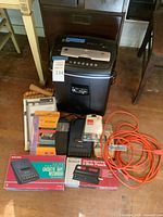 Group shot showing shredder, cassette recorder box, 3-hole punch box, extension cord, misc items