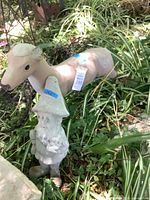 Beige deer statue and grey gnome in garden setting