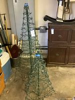 Both wire frame lighted trees standing side by side