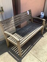 Full view of wooden bench against wall