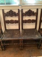 Front view of both chairs showing carved backs and overall form