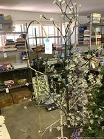 Pair of white/off-white artificial trees on storage floor