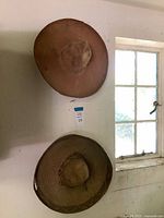 Both straw sombreros hung on wall showing overall size and color