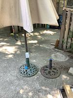 Umbrella mounted in green base beside separate brown base