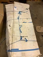 Full view of damaged white cardboard box tied with blue twine