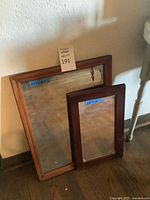 Both wood framed mirrors leaning against wall