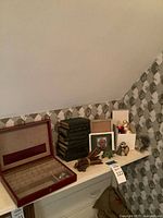 Overall lot showing books, jewelry case, ornaments on shelf