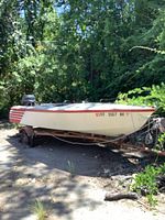 Full view of boat on trailer with motor attached