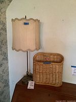 Table lamp beside wicker magazine holder on table