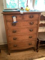 Front view of six-drawer wooden dresser showing all drawers and pulls