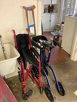 Transport wheelchair, rollator walker and crutches grouped together