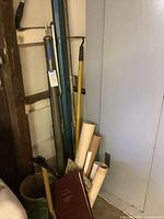 Rolled maps and burgundy clothbound atlas leaning in corner