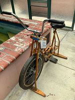 Full view of Schwinn orange exercise bike next to pool, showing overall design and condition