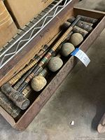Open wooden box showing mallets, balls, stakes