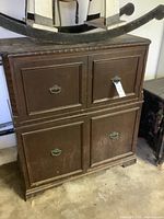 Front view of wood record player cabinet showing four doors and hardware