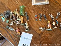Group of painted metal figures, animals and accessories spread on table