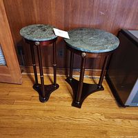 Front view of two wooden plant stands with green marble tops showing full height and design