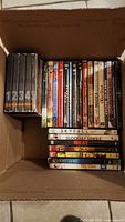 Box containing DVDs with various movie and TV series titles visible.