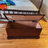 Front angled photo of the open dark cherry wood cedar chest showing exterior and partial interior.