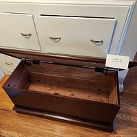 Top-down photo of the cedar chest with lid open showing natural cedar wood interior and lock mechanism on the front.