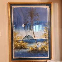 Full view of framed oasis artwork showing palm tree, pyramids, moon, and water on cloth.