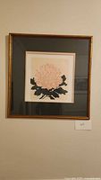 Framed floral art print hung on a wall showing overall presentation, frame, and matting.