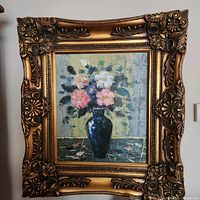 Front view showing entire framed oil painting with floral subject and textured background.
