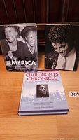 Three large hardcover history and civil rights books arranged on a wooden surface, showing covers of each book.