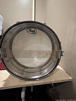 Natural wood-finish bass drum with clear Pearl front head