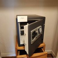 Photo showing the open safe with interior shelves and the locking door.