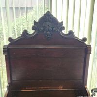 Close-up of vintage dark wood headboard with decorative carving