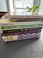 Stack of eight cookbooks showing titles and condition, used with visible wear.