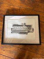 Frontal view of the framed watercolour painting showing a couch and a broken glass corner on the upper left.