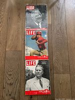 Photo showing three LIFE magazines from 1948, stacked vertically on a wooden floor. Covers display an elderly man in glasses (Nov 22), a football player in red (Sept 27), and a man in a suit (Sept 13).