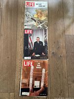 Three LIFE magazines laid out on wooden floor, clearly showing covers from August 6, 1965, December 13, 1963, and July 29, 1966.