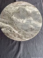 Top view of circular marble plate showing grey and white marble pattern.