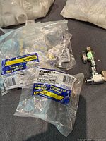 Eight Brass Craft KTBRPX 1/4 turn chrome angle ball valves in sealed packaging, and two additional loose valves seen outside packaging.