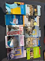 Photo showing all eight travel books grouped on a wooden surface. Titles and covers are visible, confirming the travel destinations and guide publishers.