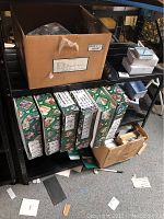 Shelf view showing six green decorative Christmas card boxes and a Ron Edelheiser Illusions Studios box