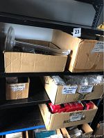 Shelves holding boxes labeled for shelves, small accessories, and Christmas string lights in red boxes.