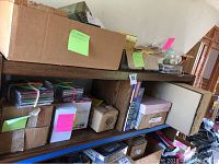 Photo of wooden shelving unit with multiple cardboard boxes labeled for Christmas decor and ornaments, showing stored household decor items.