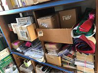 Shelves with boxes containing books labeled Grimm's Fairy Tales and Dracula, and various other boxed items including cards and papers.