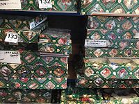 Shelving holding multiple Old World Christmas green patterned boxes
