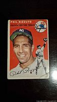 Front view of the 1954 Topps Phil Rizzuto baseball card showing player portrait, team logo, and action image.